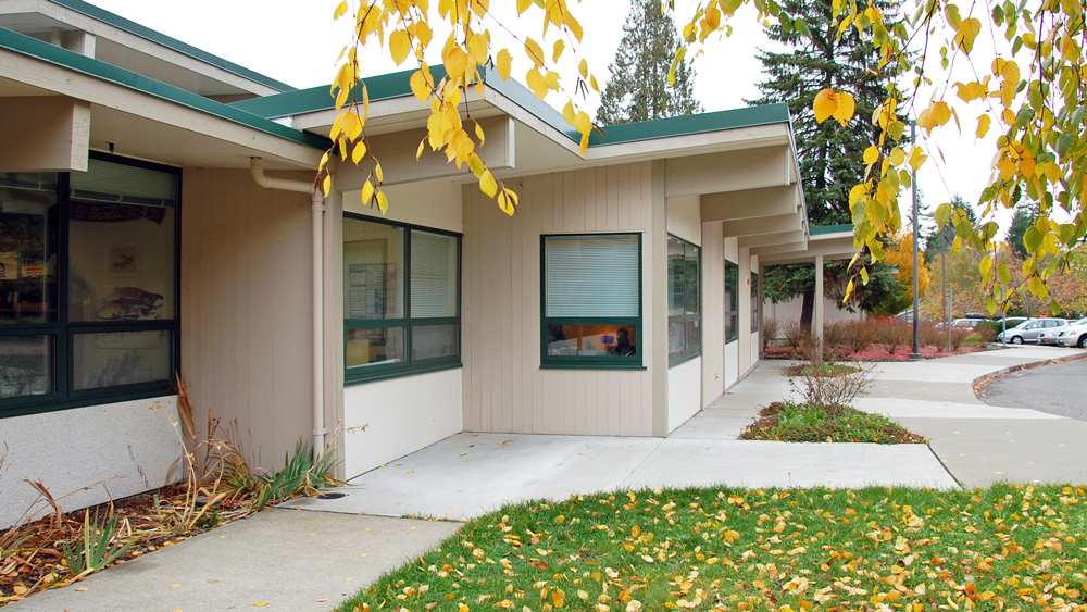 Exterior walkway and classroom wing of LP Brown Elementary School in west Olympia, with yellow autumn leaves in the foreground